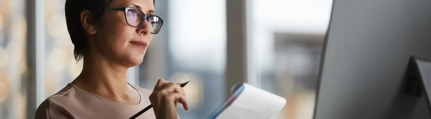 Accountant at computer with notebook