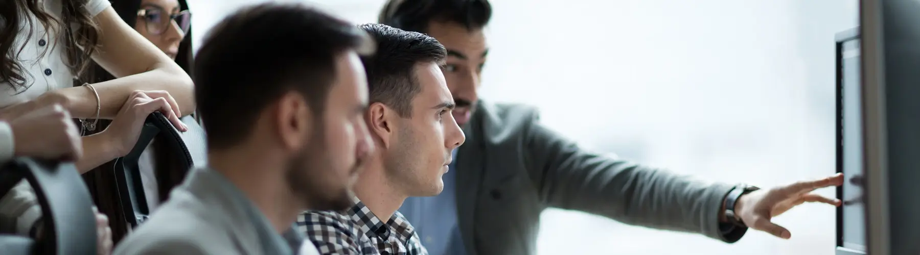 Man refers to computer screen with team